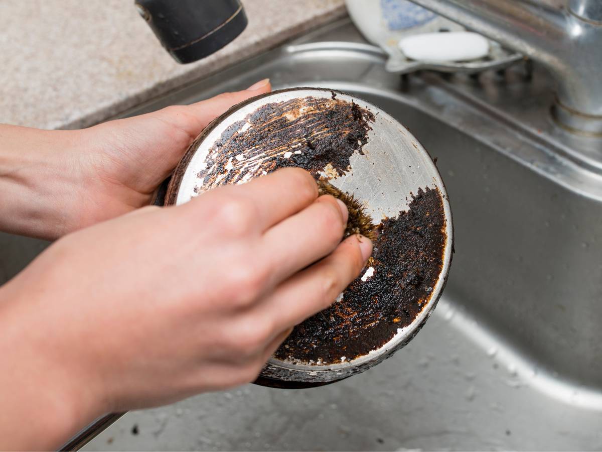 Czyszczenie garnka. Obrazek w artykule Jak usunąć spalenizną z garnka? Sposoby na spaleniznę