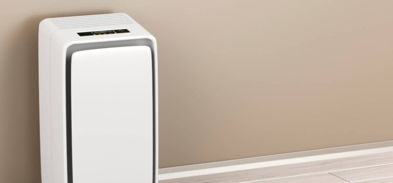 Na zdjęciu nawilżacz powietrza, stojący na tle ściany w kolorze brązowym