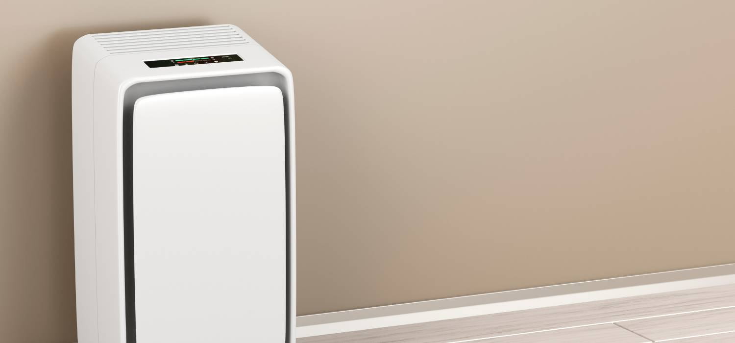 Na zdjęciu nawilżacz powietrza, stojący na tle ściany w kolorze brązowym