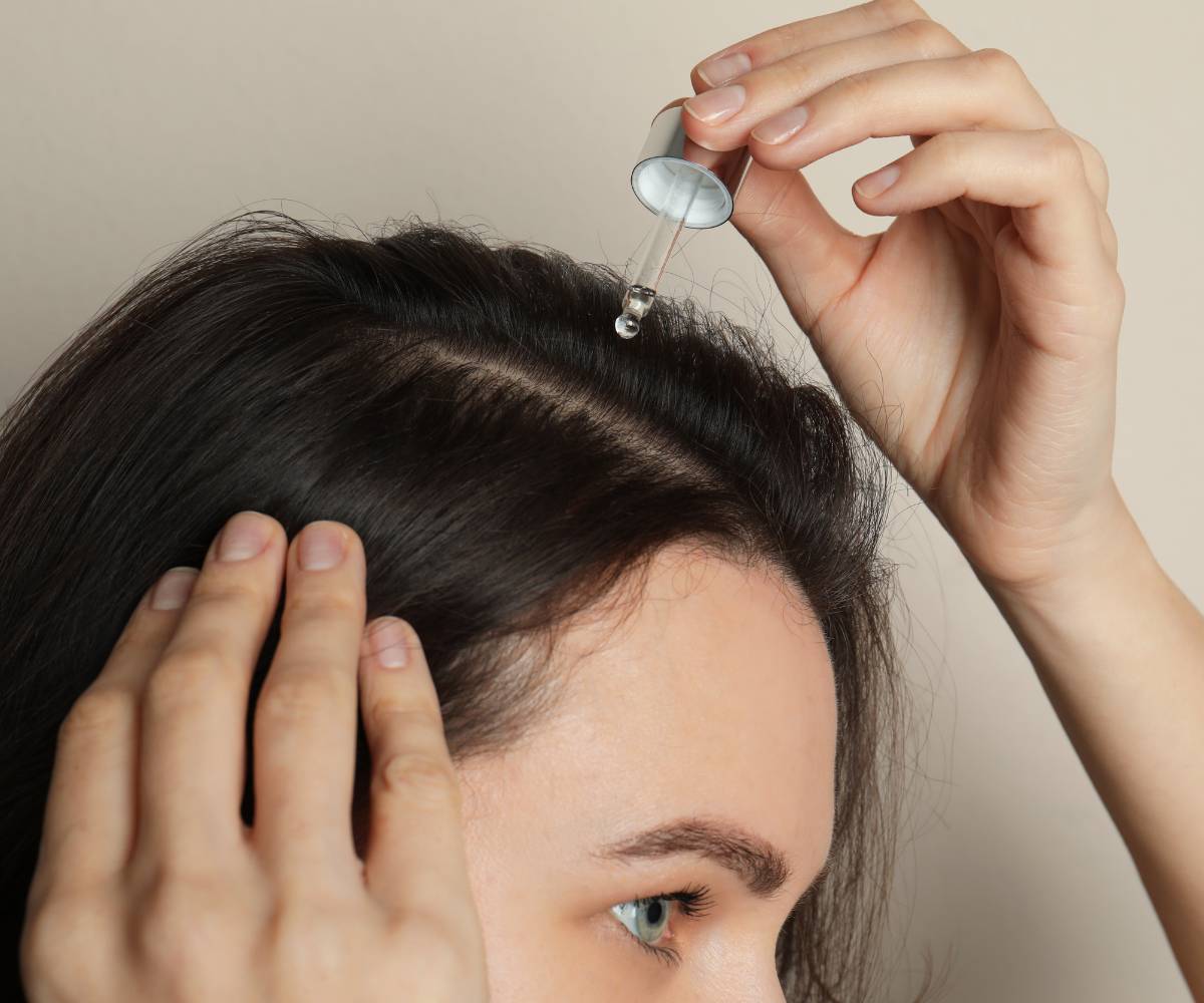 Na zdjęciu kobieta z aplikatorem. Przeprowadza olejowanie włosów