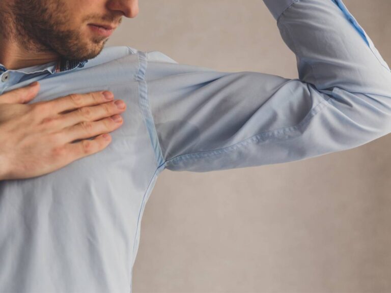 Mężczyzna w przepoconej koszuli. Obrazek w artykule Jak się mniej pocić? Sposoby na mniejszą potliwość
