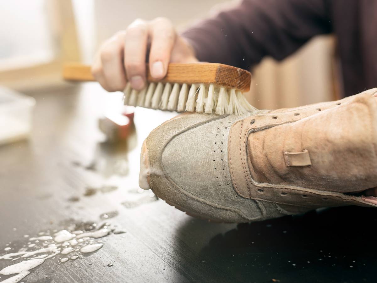 Szorowanie butów szczotką. Obrazek w artykule Czym wyczyścić białe trampki? Odkrywamy tricki na przywrócenie bieli butom sportowym