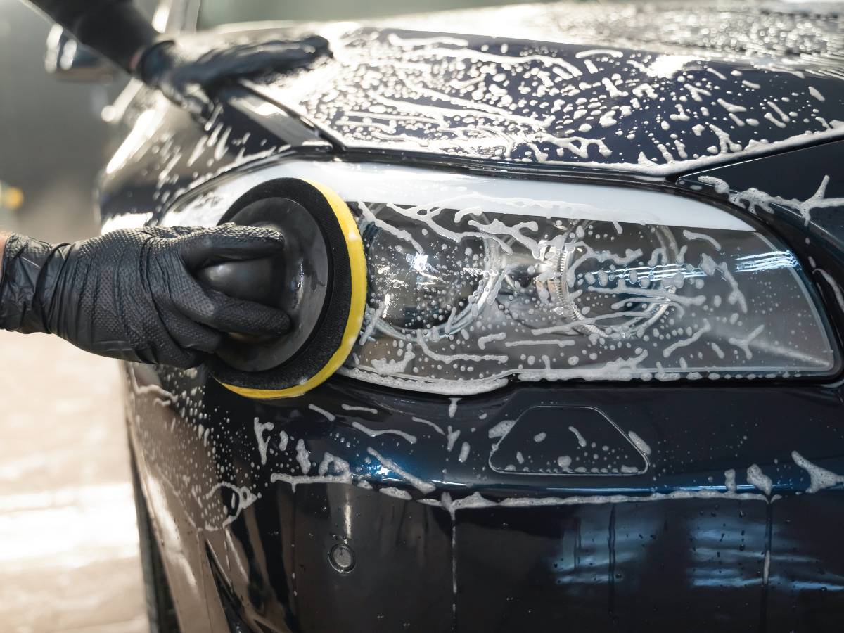 Mycia samochpdu i lamp z przodu. Obrazek w artykule Czym wyczyścić lampy w samochodzie? Poznaj środki przywracające lampom blask i popraw widoczność na drodze